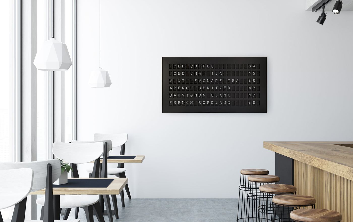 A Vestaboard split-flap display used as a drinks menu on a cafe wall